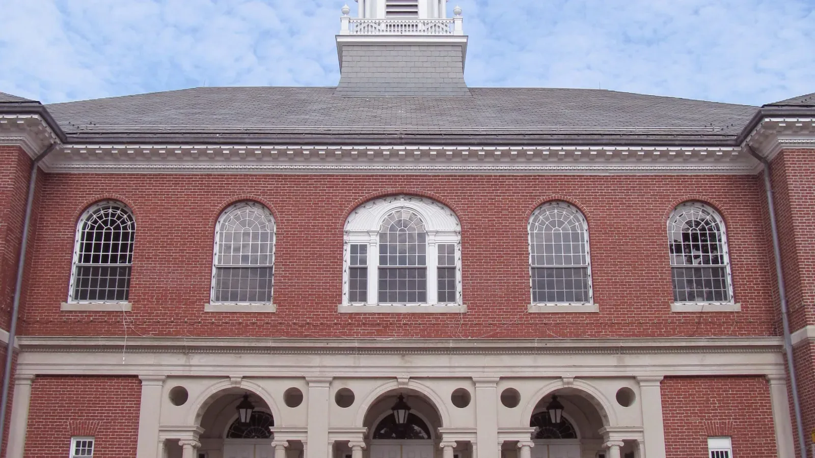 Historic red-brick civic building with arched Palladian windows and an arcaded entrance, Billerica, Massachusetts