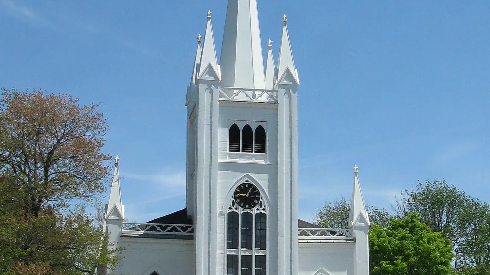White Gothic Revival church with a clock tower and tall steeple at the Old Center, North Andover, Massachusetts